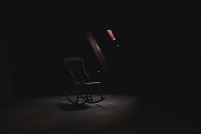 棕色的木摇椅在黑暗的房间里
